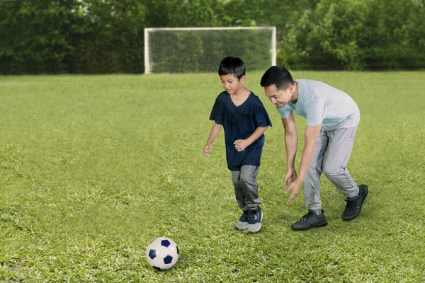 サッカー場で息子とサッカーをしている間 若い男の写真は幸せそうに見える — ストック写真