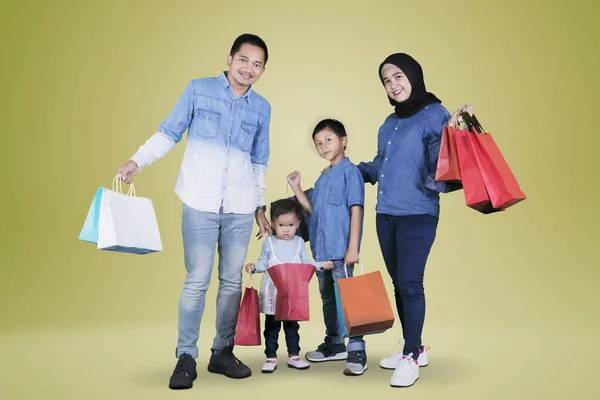 Bild Asiatiska Familjen Håller Shoppingväskor Stående Studion Med Gyllene Färg — Stockfoto
