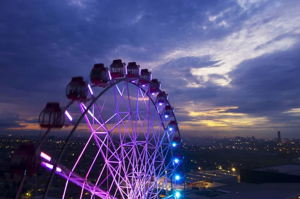 近代的な都市の夕暮れ空を背景に観覧車の美しい風景 — ストック写真