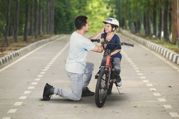 Młody Ojciec Pomoc Syna Aby Nosić Kask Przed Jazda Rowerem — Zdjęcie stockowe