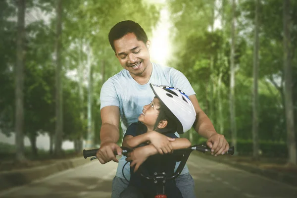 快乐的父亲和儿子一起骑自行车在公园的路上 在户外拍摄 — 图库照片