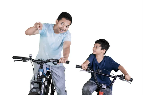 Foto Jovem Apontando Para Algo Enquanto Andava Bicicleta Com Seu — Fotografia de Stock