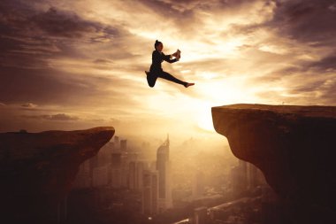 Genç iş kadını uçurum üzerinde boşluk atlama sırasında dijital tablet kullanma silüeti