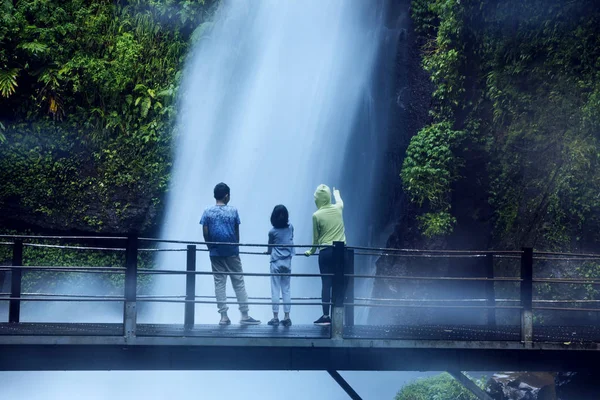 スカブミ インドネシアでその場グヌン滝の景色を眺めながら彼女の子供と退去時の若い女性 — ストック写真