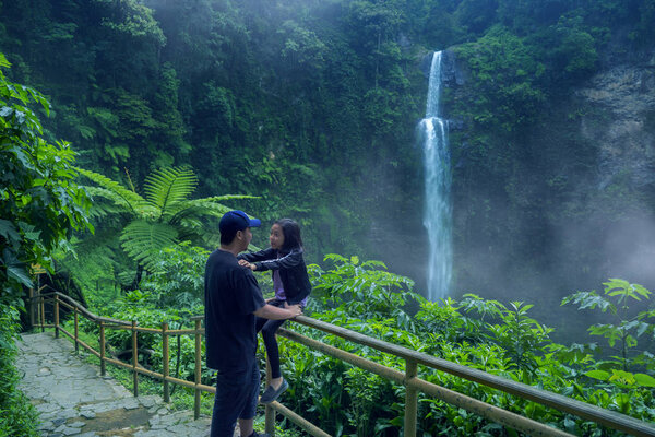 Picture of young man vacating with his daughter in the Pelangi waterfall at Bandung, Indonesia