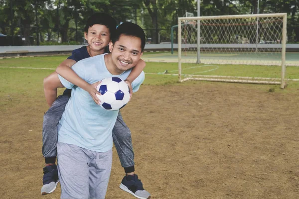 Bild Glada Far Åker Snålskjuts Sin Son Efter Spelar Fotboll — Stockfoto