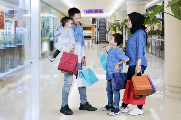 Imagen Familia Musulmana Sosteniendo Bolsas Compras Mientras Hablan Centro Comercial —  Fotos de Stock