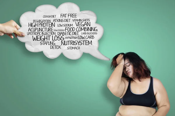 悲伤的肥胖妇女穿着运动服 而认为她的问题在演播室的图像 — 图库照片
