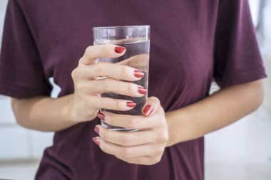 Genç kadın elinde bir bardak taze su tutarak yakın çekim 