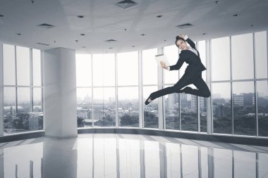 Resim kadın Yöneticisi ofiste dijital tablet tutarken dans ederek başarı kutluyor