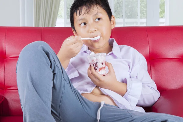 Close Menino Obeso Comendo Saboroso Sorvete Enquanto Sentado Sofá Tiro — Fotografia de Stock