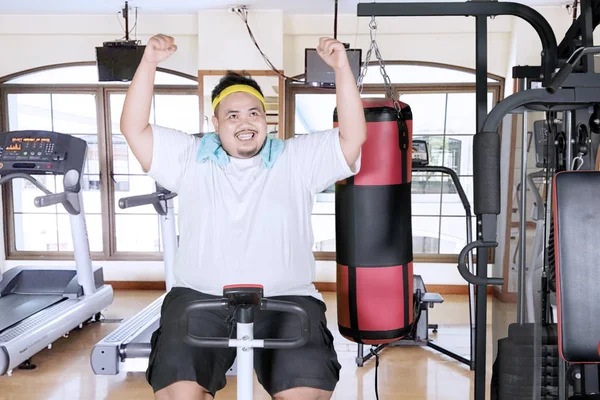 Picture Excited Fat Man Lifting Hands While Using Exercise Bike — Stock Photo, Image