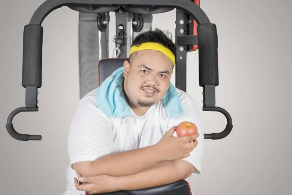 Imagem Jovem Gordo Segurando Uma Maçã Fresca Enquanto Sentado Máquina — Fotografia de Stock