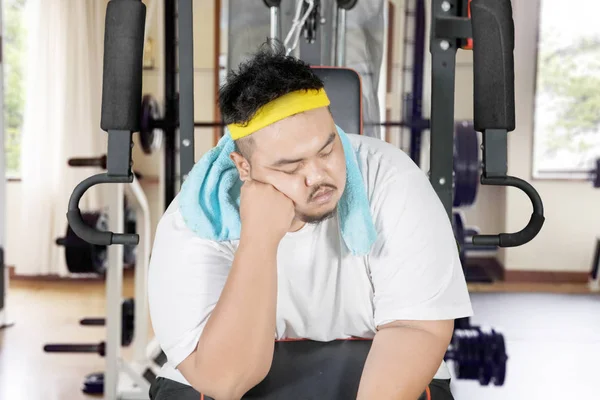 年轻肥胖男子在运动机器上睡觉时看起来很懒 在健身中心被枪杀 — 图库照片