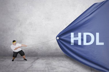 Hdl kelime başlığında çekmek için bir zincir kullanırken spor giyim giymiş şişman genç bir adam resmi