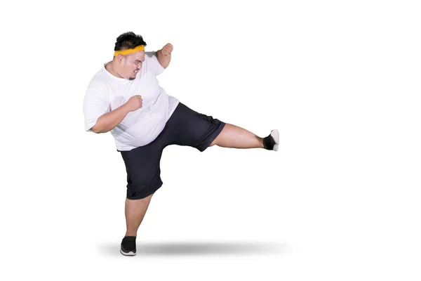 배경에 스튜디오에서 차기를 운동복을 뚱뚱한 남자의 초상화 — 스톡 사진