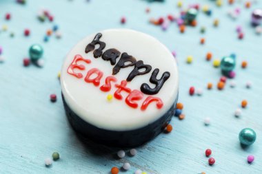 Ahşap masa üzerinde şeker ile beyaz çikolata Paskalya metnin yakın çekim