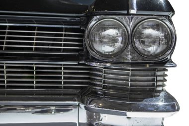 Beyaz arka plan üzerinde izole klasik siyah bir araba, iki farlar, yakın çekim