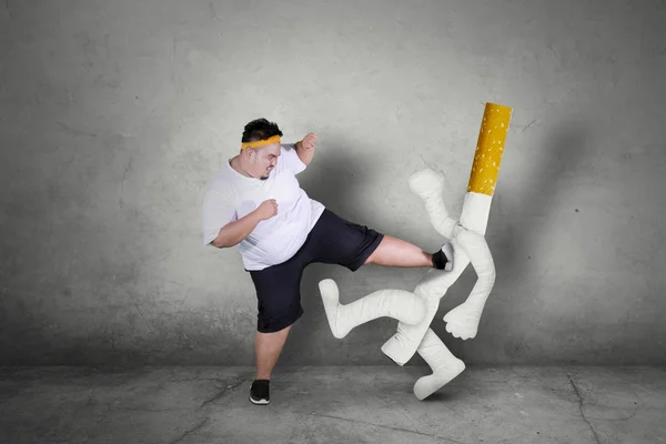 Asian obese man kicking a cigarette — Stock Photo, Image