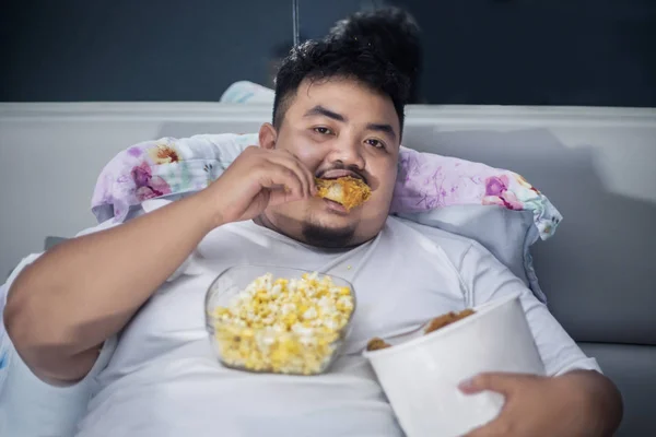 Hebzuchtige zwaarlijvige man eet gebakken kippen vóór slaap — Stockfoto