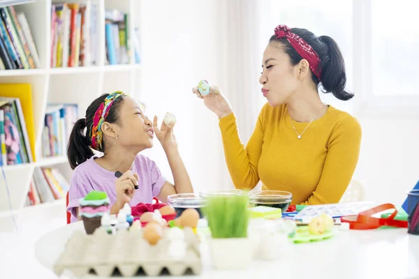 Malá holčička řídí její matka k barvení kraslic — Stock fotografie