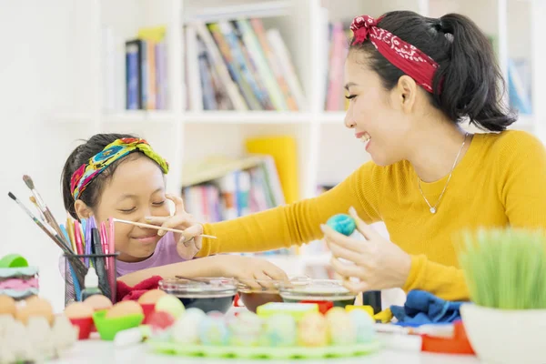 Gadis kecil belajar untuk mewarnai telur dengan ibunya — Stok Foto