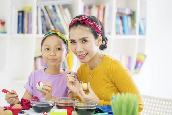 Madre e hijo decorando huevos con tinte líquido — Foto de Stock