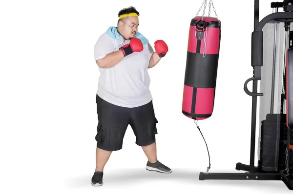 Young obese man carrying fat word on studio — Stock Photo, Image