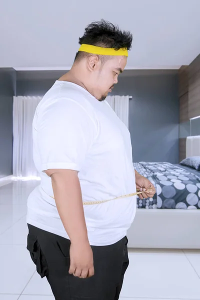 Obézní mladík nesoucí tuku slovo na studio — Stock fotografie