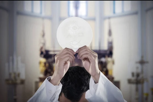 Pasteur main lève un pain de communion dans l'église — Photo