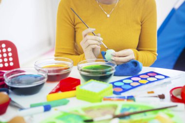 Eller genç kadın renk yumurta için bir fırça kullanarak