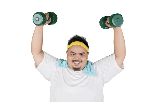 Young fat man lifting dumbbells in the studio — Stock Photo, Image