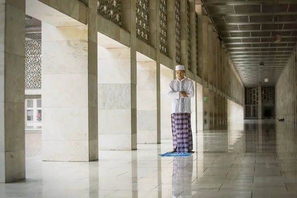Азиатский мужчина, совершающий молитву в мечети Истикляль — стоковое фото
