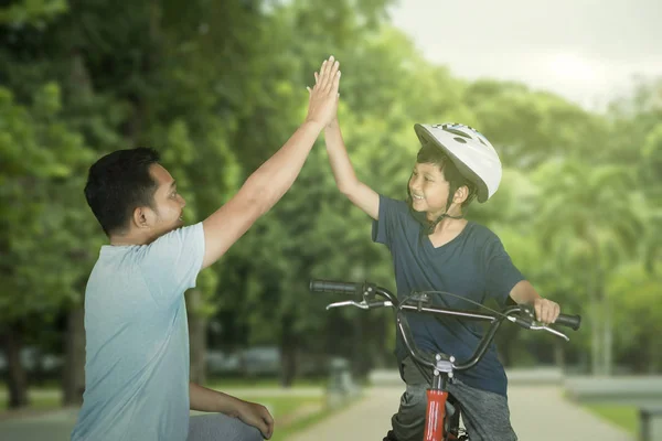 Παιδί δίνοντας υψηλό πέντε χέρια με τον πατέρα του στο πάρκο — Φωτογραφία Αρχείου