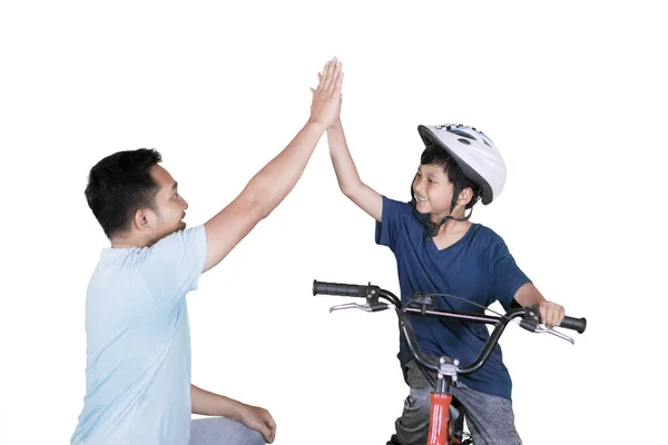 Niño y padre haciendo chocar los cinco en bicicleta — Foto de Stock