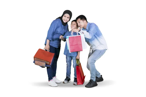Rodina drží nákupní tašky a podívat se na něco — Stock fotografie