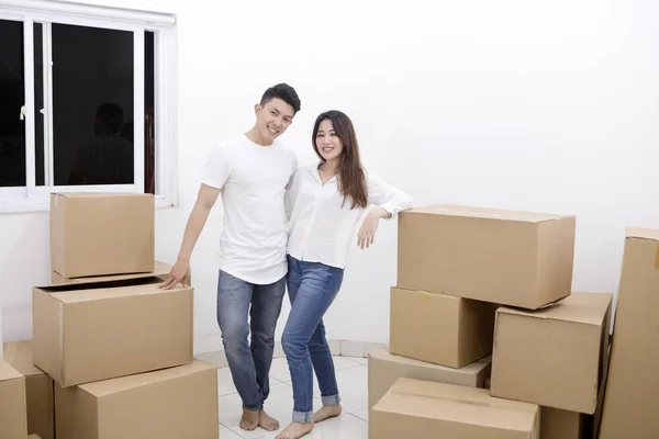 Щаслива пара, що стоїть зі стопою картонних коробок — стокове фото