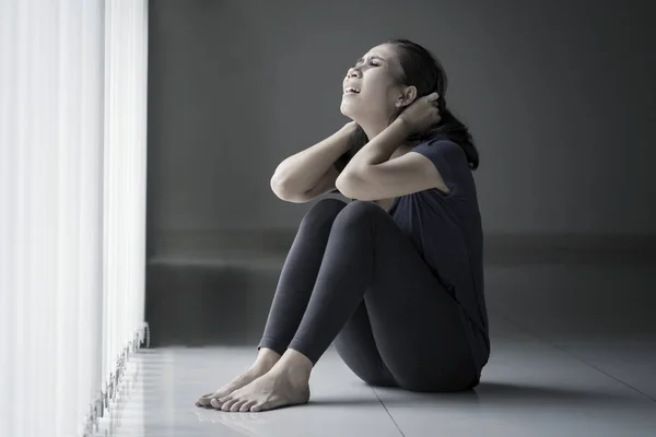 Magere vrouw ziet er wanhopig in de buurt van het raam — Stockfoto