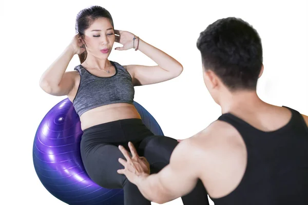 Woman doing crunches exercise with her trainer — Stock Photo, Image