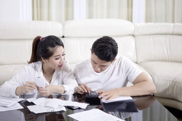 Jong paar berekenen van hun huishoudelijke financiën — Stockfoto