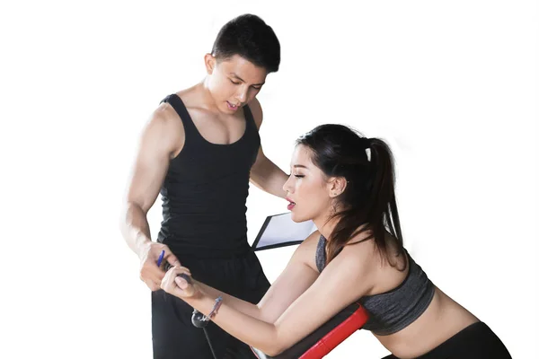 Young woman helped by trainer to exercise — Stock Photo, Image