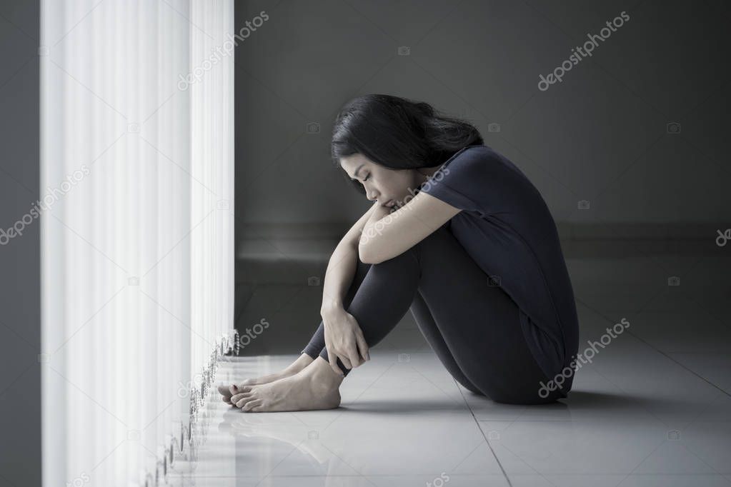 Unhealthy woman sitting near the window