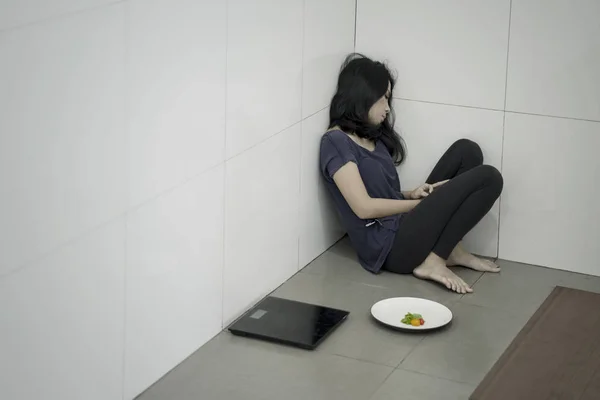 Anorexia mulher com salada e balança de peso — Fotografia de Stock