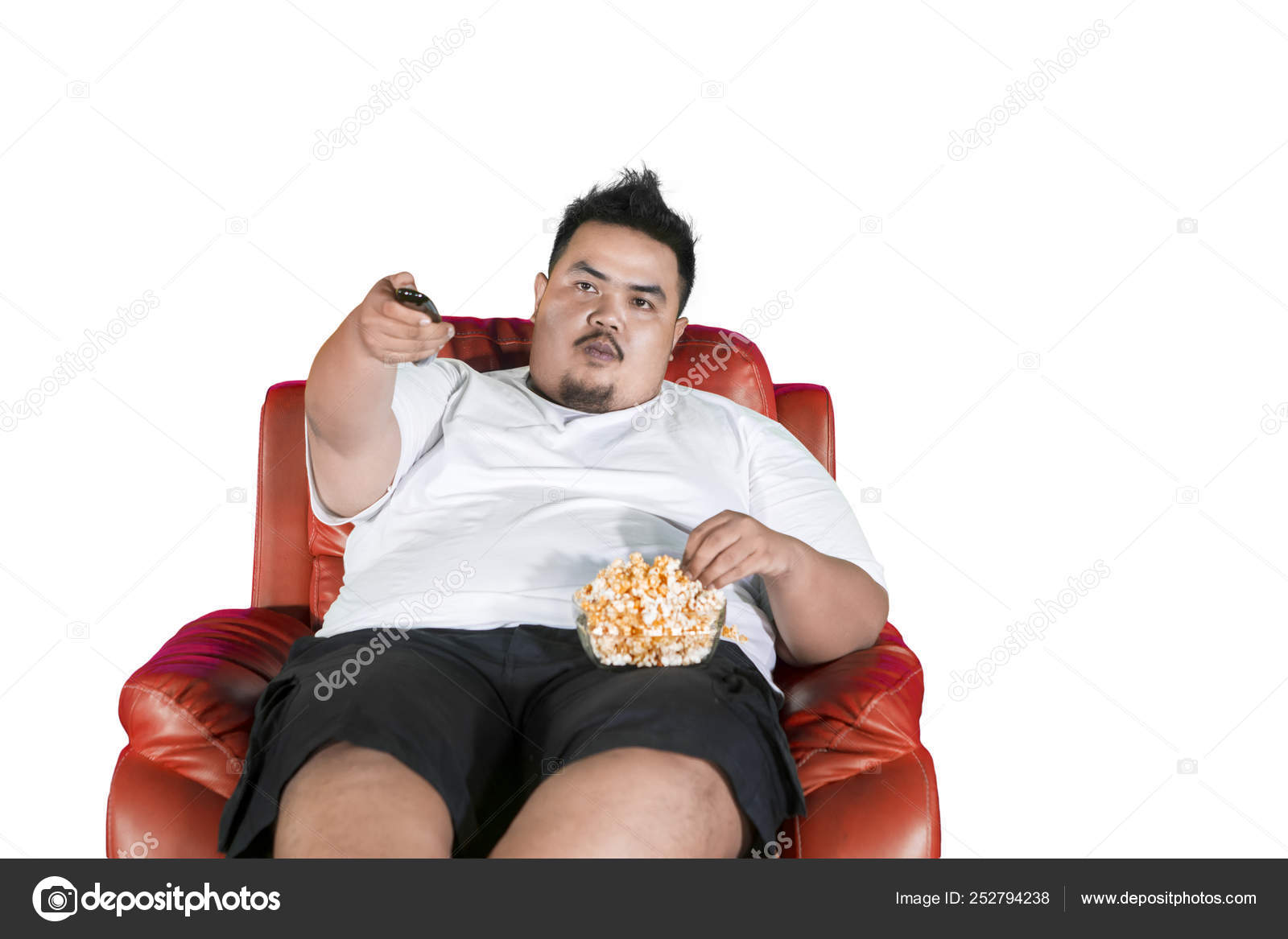 肥満男性はテレビを見ている間にポップコーンを食べる ストック写真 C Realinemedia