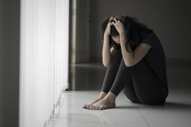 Umutsuz kadın pencerenin yanında oturuyor 