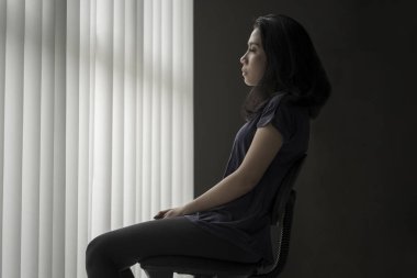 Üzgün kadın sandalyede oturan