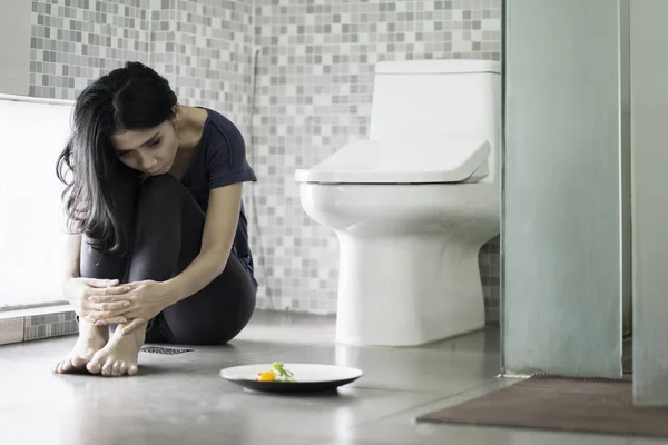 Wanita tertekan duduk dengan salad di kamar mandi — Stok Foto