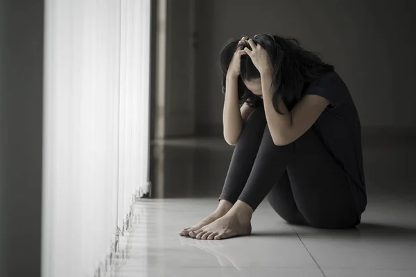 Desperate woman sitting near the window — Stock Photo, Image