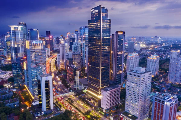 Glowing light skyscrapers with traffic at evening — Stock Photo, Image