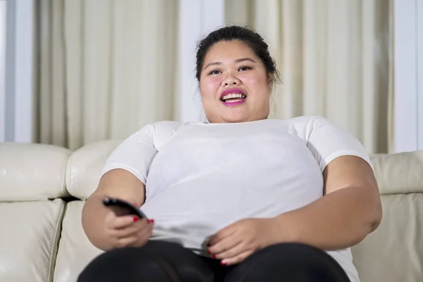 Толстая женщина смотрит телевизор в гостиной — стоковое фото